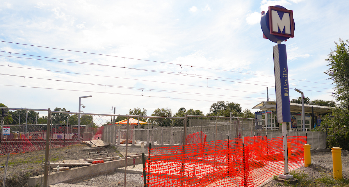 Construction fencing underneath a MetroLink station sign.