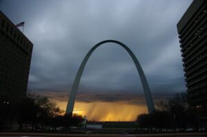 Photo of cloudy skies and rainfall behind the Gateway Arch